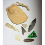 An opal arrow head, a green glass arrow head and five related pieces.