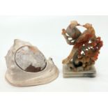 A conch shell, the oval cameo carved with a bacchante and a soapstone carved group of birds.