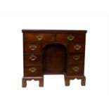A George III mahogany kneehole desk, with an arrangement of eight drawers on bracket feet. (
