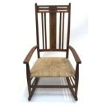 An Arts & Crafts inlaid oak rocking chair.