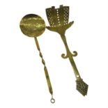A brass cream skimmer, circa 1900, pierced with an open armed figure and with crown terminal, and