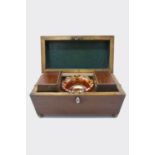 A Regency mahogany tea caddy of sarcophagus shape, with boxwood stringing and lion's mask handles,