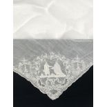 An early 19th century white work type hankerchief, embroidered with two male figures, flowers and