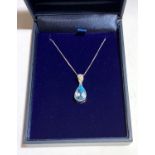 A contemporary18ct white gold pendant set a pear shaped aquamarine beneath a diamond.