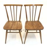 Two Ercol dining chairs, each with a triple spindle back.