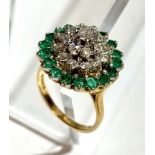 An 18ct gold emerald and diamond flowerhead cluster ring.