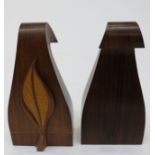 A decorative pair of arts and crafts bookends, the swept weighted bases with applied satinwood