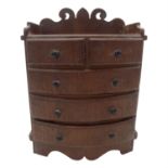 A miniature mahogany bow front chest of drawers, with two short and three long graduated drawers. (