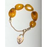 A 9ct gold and amber bracelet with padlock clasp.