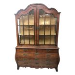 A Dutch walnut display cabinet, with a pair of shaped glazed doors, the lower bombe part with two