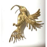 A gold humming bird brooch.