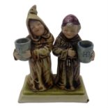 Attributed to Doulton, a figure group of two monks, moulded and painted in enamels underglaze,