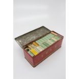 Cigarette cards - a tin containing 26 cigarette packets, each containing what appears to be full