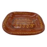 An early 19th century slipware baking dish, decorated with trailed slip decoration. (Dimensions: