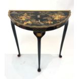 A 1930's black lacquered demi lune side table, with circular tapering legs and pad feet. (