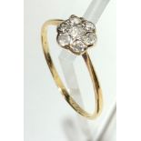 A diamond daisy cluster gold ring.