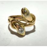 A 9ct gold twin headed snake ring, one head set a white diamond, the other a yellow diamond, 5.6g.