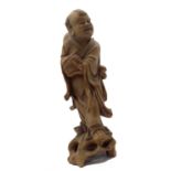 A Chinese carved wood figure of a laughing man holding a basket, circa 1900 - 1920. (Dimensions: