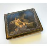 A lacquered table snuff box with painted classical panel of scantily clad recumbent goddess attended