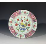 A Chinese famille rose plate, 18th century, decorated with a cockerel amongst flowering branches. (