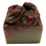 A Chinese hardstone seal, surmounted by a stylised dragon, height 5cm.