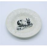 A creamware nursery plate, circa. 1900, with central black printed decoration of a rabbit. (