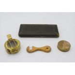 A brass mariner's compass, a marching compass, a boxwood range finder and a boxed set of drawing