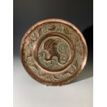 An Arts and Crafts period copper tray decorated with dragons. (Dimensions: Diameter 38cm.)(