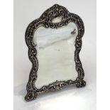 An Edwardian silver mounted dressing table mirror with scrolling acanthus and floral repousse