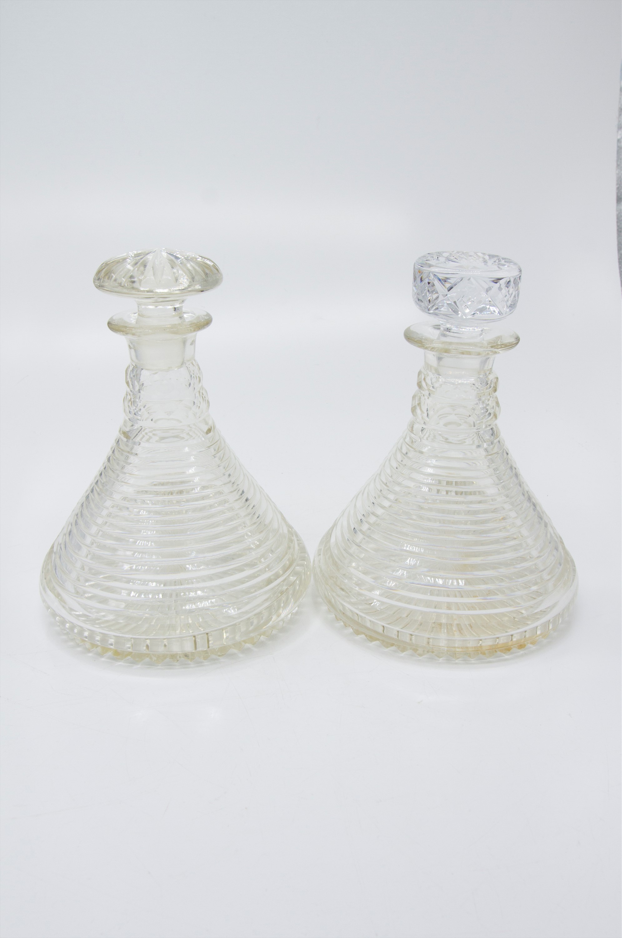 A pair of step cut circular ship's decanters, early 20th century. (Dimensions: Height 23cm.)(