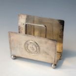 A Wai Kee Chinese silver letter rack on bun feet, embossed with 'Medio Tutissimus Ibis' motto.