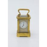 A Miniature French brass carriage timepiece, with frosted mask, circular dial with Arabic