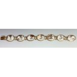 A cameo chariot bracelet with seven gold mounted shell panels each carved with a classical