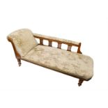 A late Victorian oak chaise longue. (Dimensions: Height 76cm, width 168cm.)(Height 76cm, width