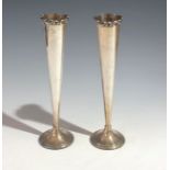 A pair of tapering Mappin & Webb silver vases with applied acanthus rims and filled silver feet.