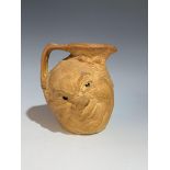 A Martin Brothers stoneware jug modelled with two grotesque faces, incised to base 'R. W Martin +