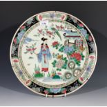 A Chinese famille verte charger, early 20th century, decorated with a garden scene with a female