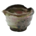 A small Japanese pottery spouted bowl, 19th century or earlier, with uneven rim, old collector's