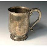 A plain bellied silver footed pint mug with scrolling handle, 13.5oz.