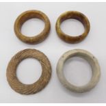 Four Chinese hardstone bangles. (Dimensions: The largest 9.5cm exterior diameter.)(The largest 9.5cm