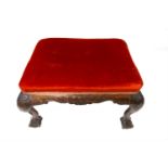 A carved mahogany velvet upholstered stool, 19th century, with cabriole legs and ball and claw feet.