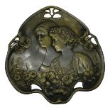 A continental cast brass Art Nouveau dish, circa 1900, decorated in relief with two young women