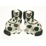 A pair of Victorian Staffordshire spaniel ornaments with green and copper lustre decoration. (