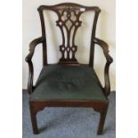 A Georgian mahogany armchair with carved top and side rails, the shaped arms with floral carved