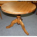 A stained pine round dining table, 85 cm diameter