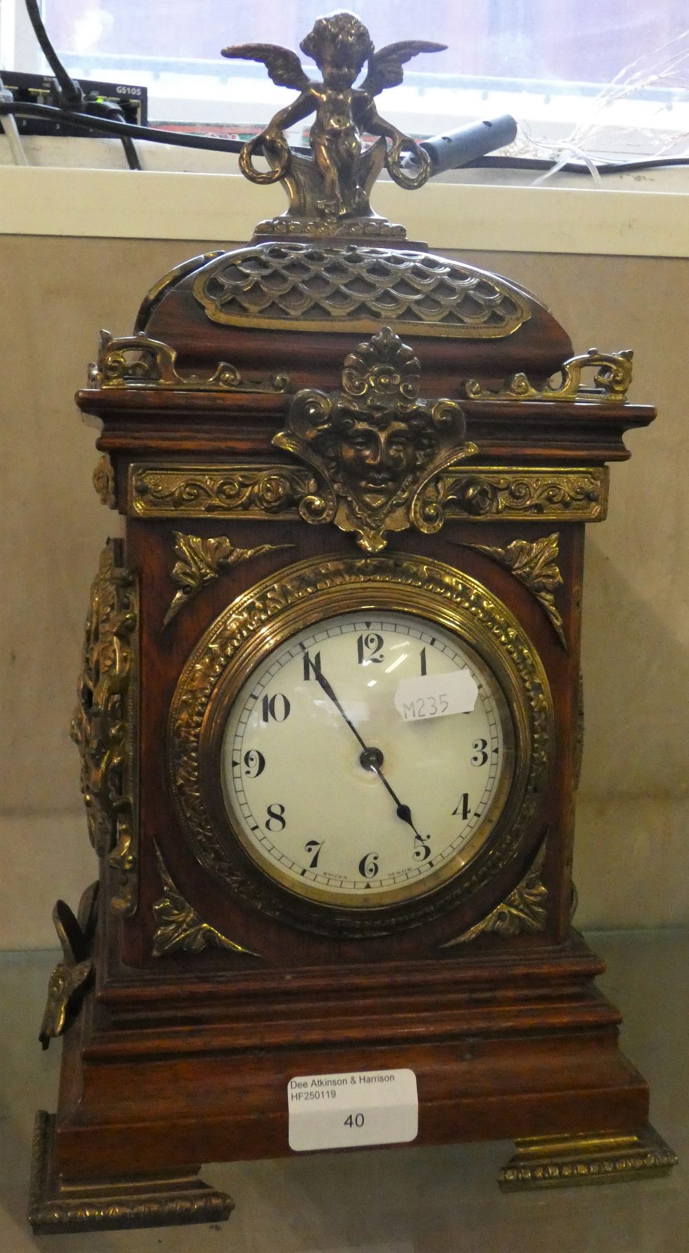 A mahogany case with brass details, manual wind mantel clock