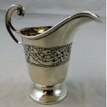 A silver Celtic cream jug, Birmingham 1928 with Dublin import mark for 1928, embossed with a band of