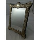 A silver easel mirror, Birmingham 1991, the bevel glass bordered by an embossed scroll border, 30