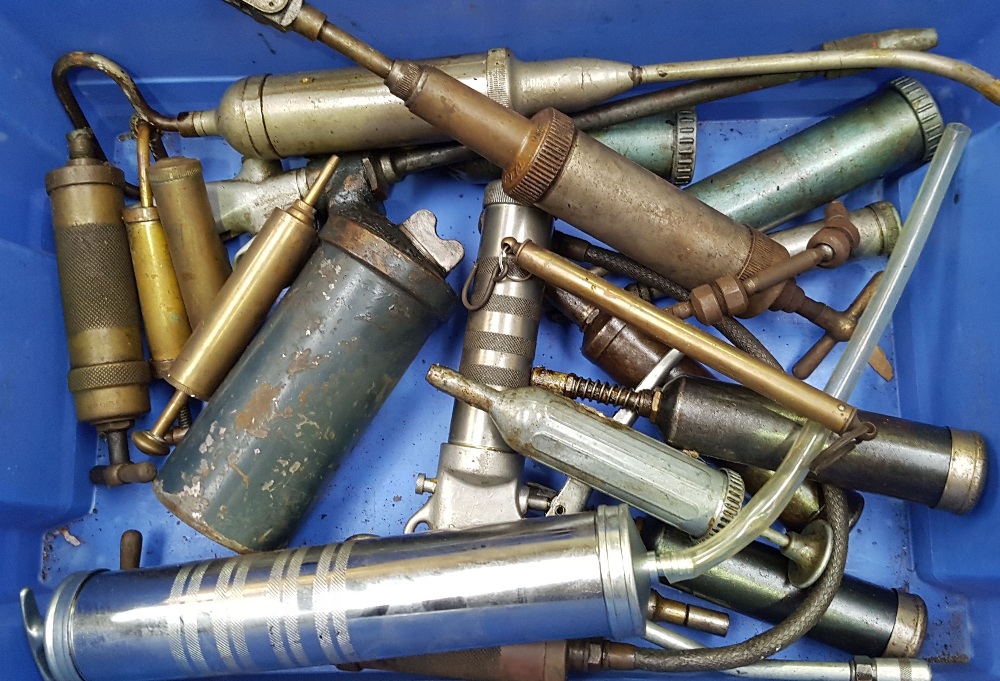 A quantity of grease guns, including brass examples.