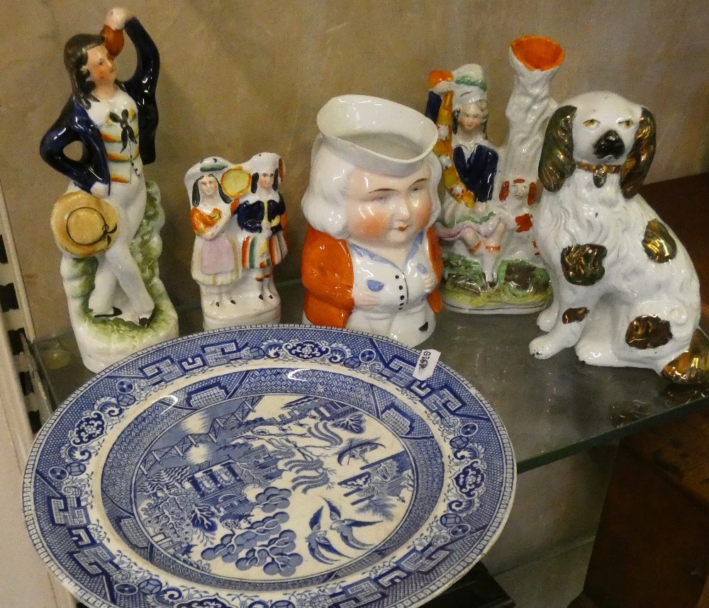 A Staffordshire spaniel together with three Staffordshire pieces, character jug and blue and white